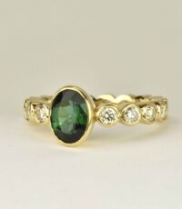 Ring in 18k gold with all around light yellow diamonds and green tourmaline